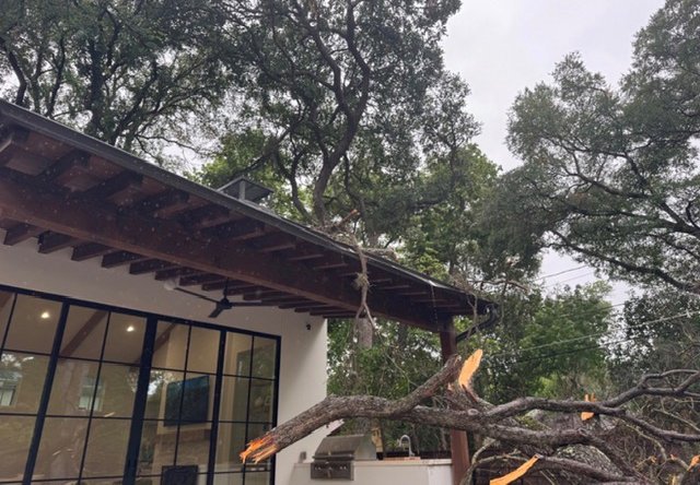 A large limb failed and came down across a home roofline and outdoor kitchen